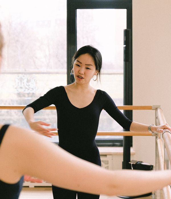 Person practicing gentle coordination movements in a dark studio